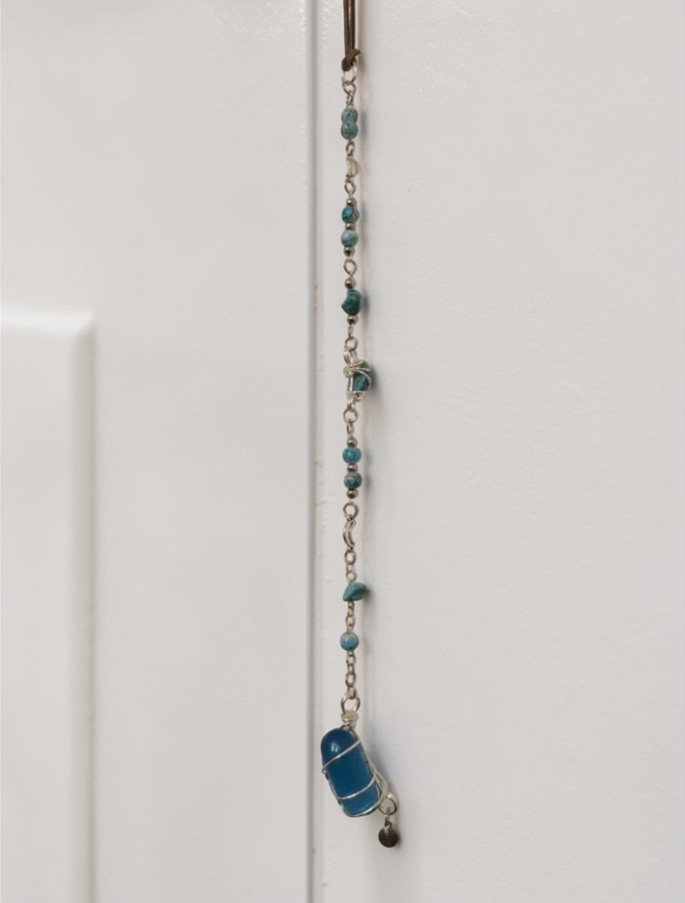 Image 6: Handmade blue gemstone wall hanging detail – decorative bead strand and crystal pendant